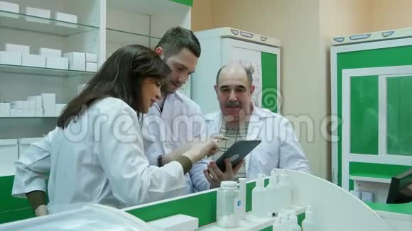 药剂师在药房使用平板电脑的积极团队视频的预览图