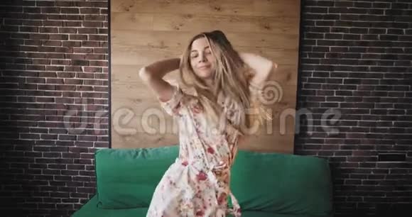 在一间城市工作室的公寓里一位漂亮的女士在镜头前跳着金色长发跳着迷人的舞蹈视频的预览图