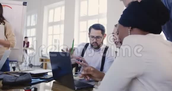 多种族专业软件开发人员与笔记本电脑一起工作在阁楼办公桌哈克顿事件讨论视频的预览图