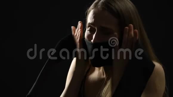 压抑的女性用深色织物闭上嘴抑制情绪性别歧视视频的预览图