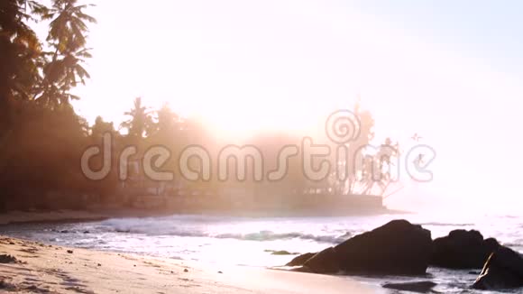 沙滩上的泡沫海浪反射阳光视频的预览图