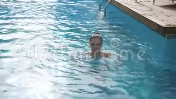少女在游泳池里玩耍和喷水视频的预览图