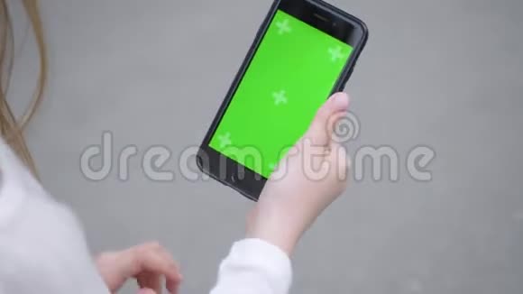 女孩正在使用智能手机与绿色屏幕双手特写视频的预览图