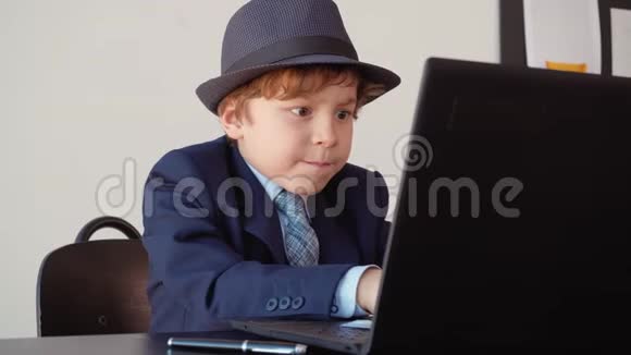 聪明的小男孩年轻企业家用电脑视频的预览图