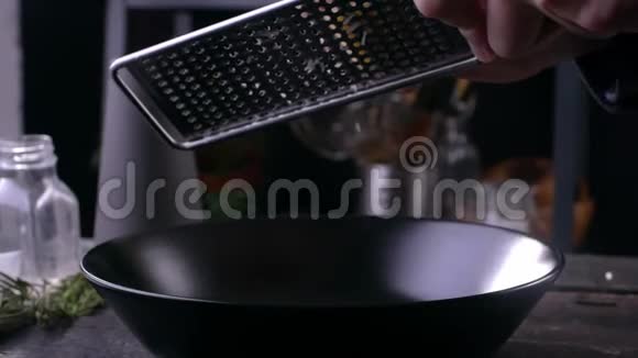厨师把帕尔马干酪擦在烤架上慢动作烹饪视频的预览图