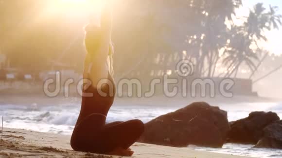 令人兴奋的女士举手在沙滩上做瑜伽视频的预览图