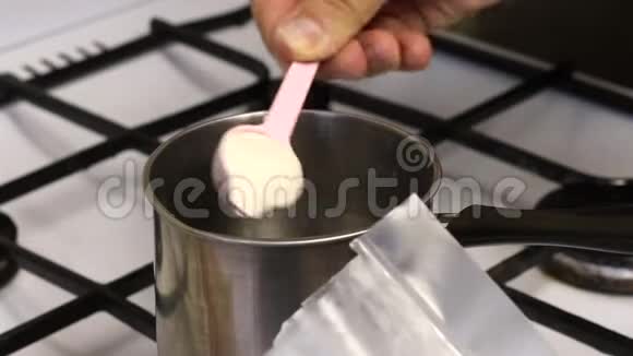 一个人在炖锅里加入琼脂糖和水来煮糖浆准备棉花糖视频的预览图