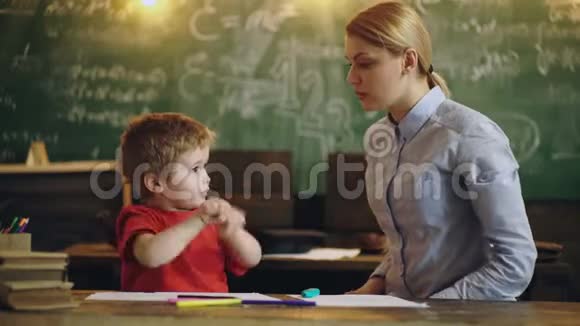 小可爱的男孩年轻的老师在教室里学习在绿色学校的背景下做练习休息视频的预览图