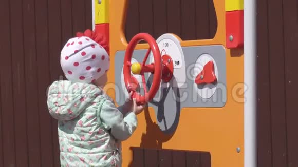 一个漂亮的白种人小女孩3岁在一个春天的日子里在一个新的多种颜色的现代操场上玩耍视频的预览图