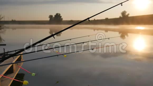 日落河上的钓鱼竿钓竿在背景的早晨天空池塘上的雾视频的预览图