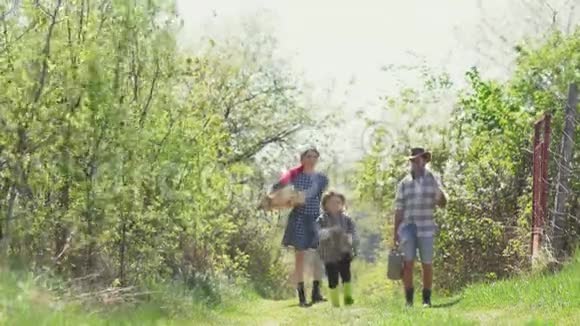 在农场好好享受家庭幸福爸爸妈妈和儿子一起玩家庭生态农场家庭农民概念春天视频的预览图