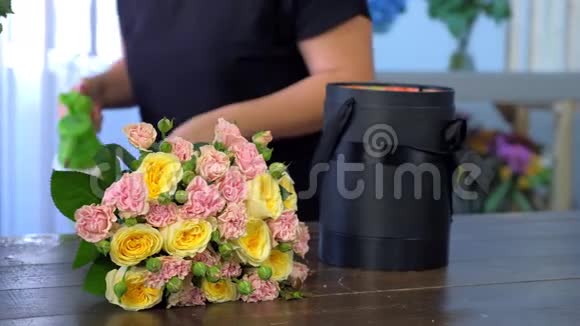 花商用水喷洒鲜花制作玫瑰花束放在盒子里视频的预览图