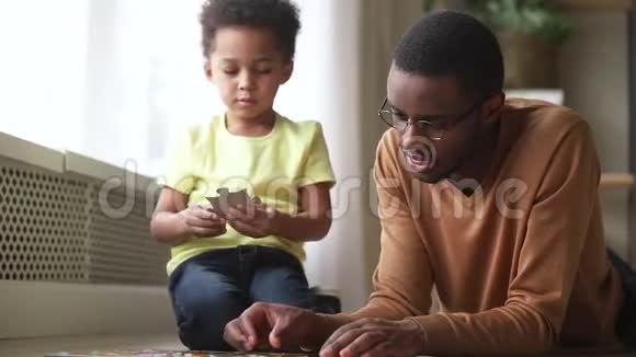 快乐可爱的小儿子玩黑人爸爸组装拼图视频的预览图