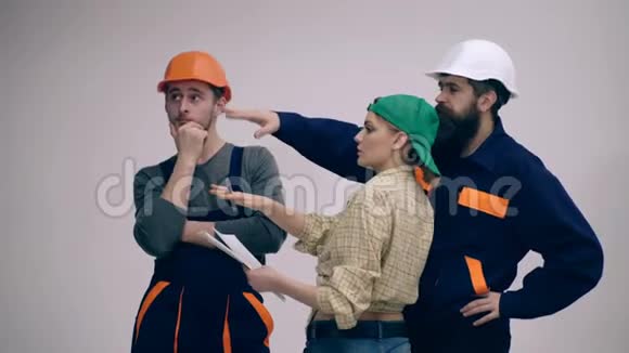一群年轻风趣勤奋的建筑工人孤立在白色上戴头盔的男女建筑工人视频的预览图