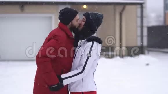 有胡子的男人和漂亮的女人在冬天的后院接吻一个男人用手套用手指触摸女孩的嘴唇视频的预览图