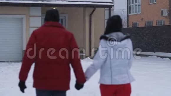 年轻的女人和留胡子的男人牵着手走在后院然后停下来亲吻快乐的一对夫妻视频的预览图