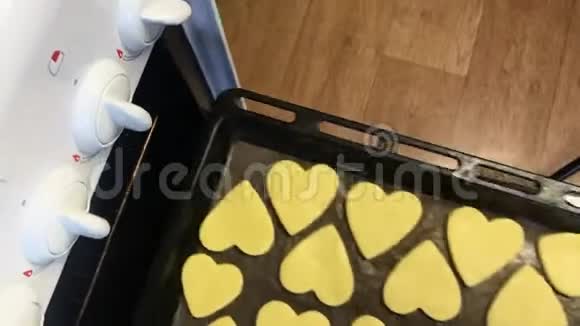 一个女人打开烤箱给饼干放空白然后关上烤箱视频的预览图