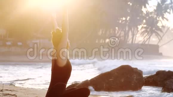 巨大的女孩向后伸展双手放在黄沙上视频的预览图