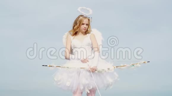 迷人的卷曲的小女孩穿着白色连衣裙和翅膀天使丘比特女孩情人节礼品卡圣诞少年丘比特视频的预览图