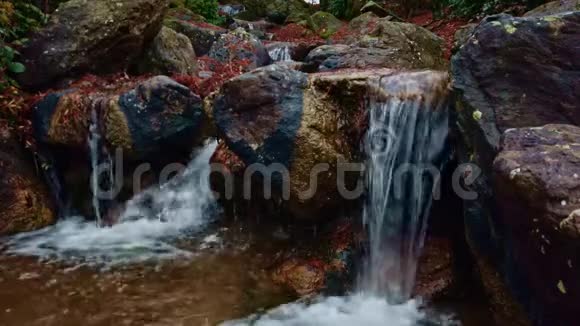 水流以瀑布的形式下降日本花园野石上的小瀑布视频的预览图