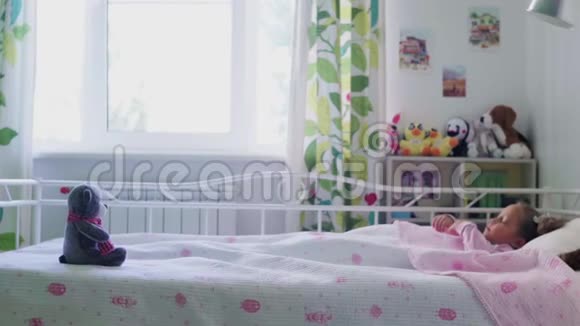 可爱的小女孩早上从床上醒来视频的预览图
