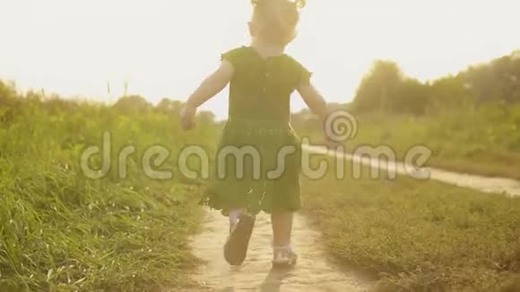 一个小女孩在阳光明媚的夏日傍晚沿着乡间小路奔跑视频的预览图