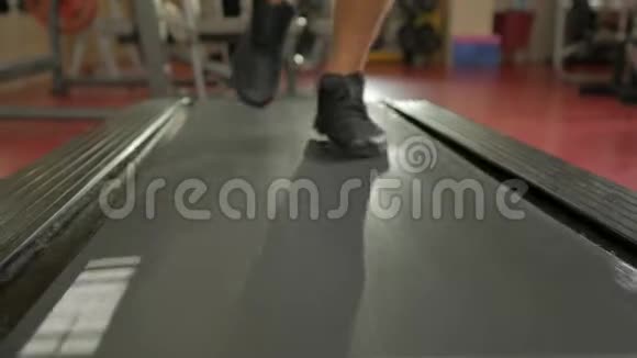 在健身健身房的跑步机上特写运动脚低视角运动鞋训练在体育俱乐部男人的腿视频的预览图