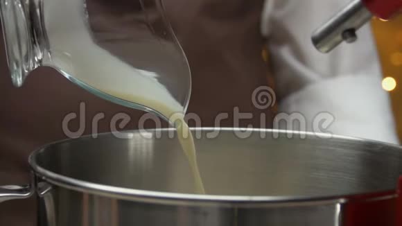 将奶油倒入金属碗中搅拌视频的预览图