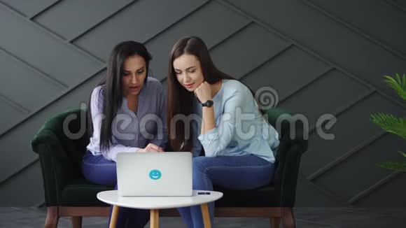 两个幸福的女人看着笔记本电脑屏幕活跃地说话视频的预览图