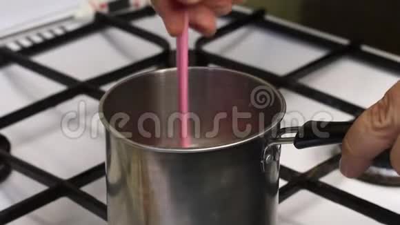 一个人把琼脂糖和水混合在平底锅里酿制棉花糖的糖浆视频的预览图