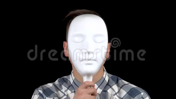 一个年轻人摘下面具脸上流露出悲伤的情绪穿衬衫的伤心人一个人藏着脸视频的预览图