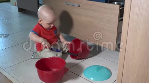 一岁的孩子独自在厨房里玩碗瓢盆视频的预览图