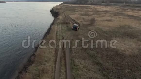 逾越节车骑在海边沿秋野野鸟瞰旅游越野SUV汽车沿海上乡间田野行驶视频的预览图