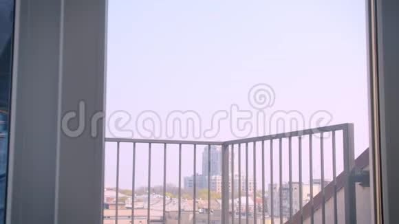 年轻的白种人情侣在阳台上拥抱欣赏壮丽的城市景色视频的预览图