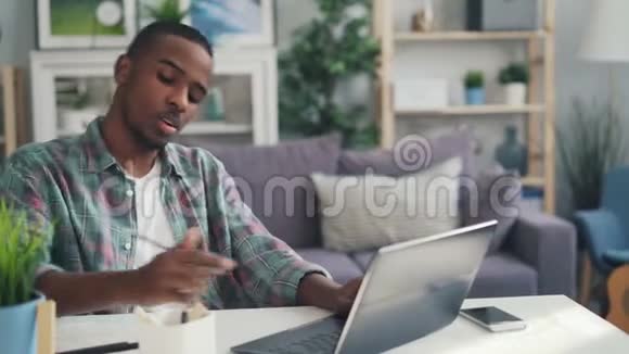 美国黑人自由职业者用笔记本电脑打字然后摸着头感到疲倦和不快乐视频的预览图