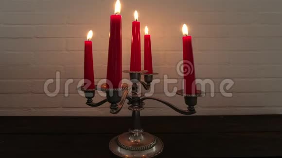 老式的银烛台和燃烧的红色蜡烛1视频的预览图
