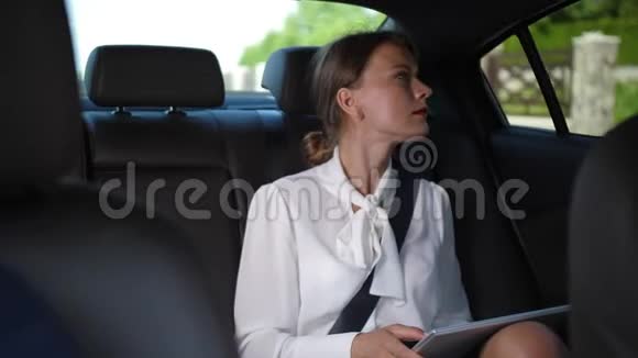 使用平板电脑的严肃女人乘出租车上班视频的预览图