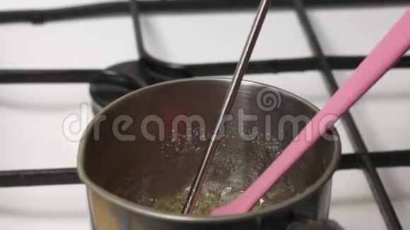 一个人把煮沸的糖浆混合成棉花糖他把温度计放进去检查温度视频的预览图