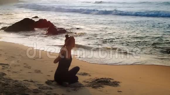 在沙滩上做瑜伽的女士视频的预览图