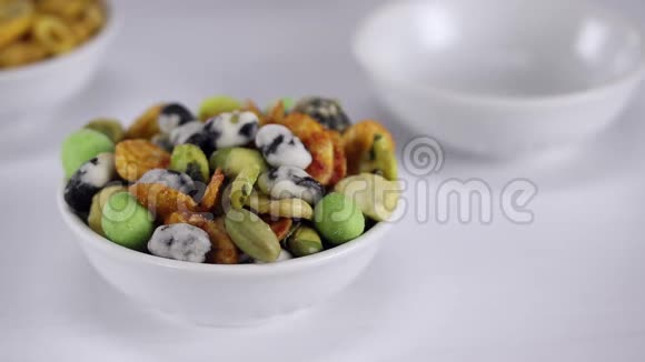有花生豌豆和芥末的日本热食放在前景的白色碗里视频的预览图