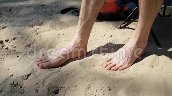 一个男人或一个青少年正在他的大脚趾上贴伤口在海滩上的沙滩上行走会伤到自己沿海污染视频的预览图