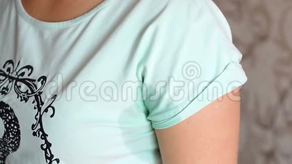 一个女人用餐巾擦拭湿汗的腋窝的特写镜头视频的预览图