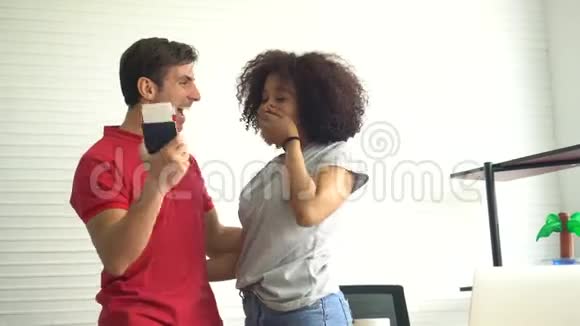 拉丁裔和黑人夫妇带着旅行票享受快乐的惊喜视频的预览图