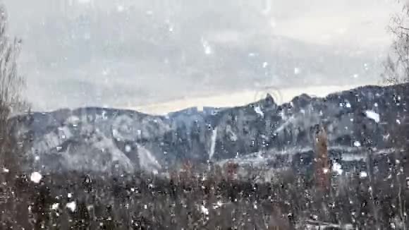 山峦背景下的冬季城市景观降雪视频的预览图