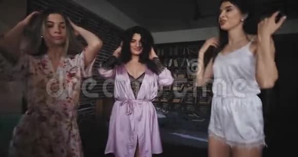四位女士跳起来跳舞穿着睡衣在家兴奋不已她们庆祝单身派对视频的预览图