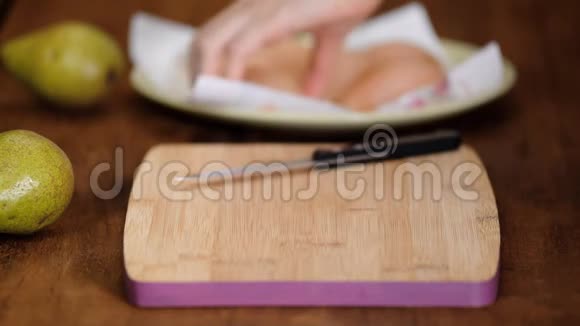 女人在切割板上切一个煮熟的梨视频的预览图