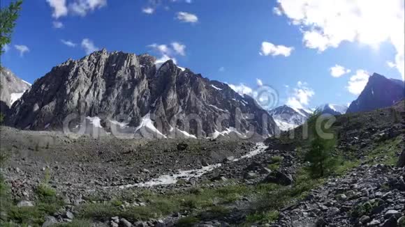 山河沿着山谷奔流陡峭的山峰雪峰的景色视频的预览图