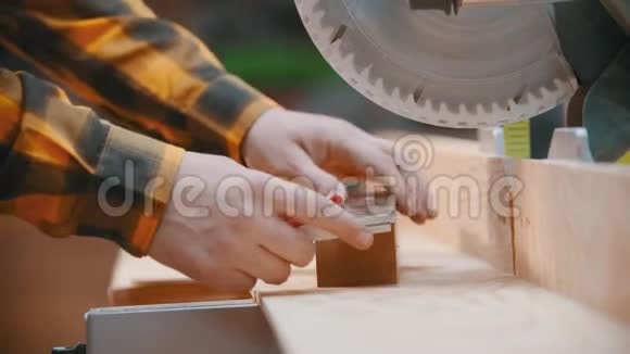 木工一名木工用铅笔和标尺在木刻上做记号一个圆锯视频的预览图