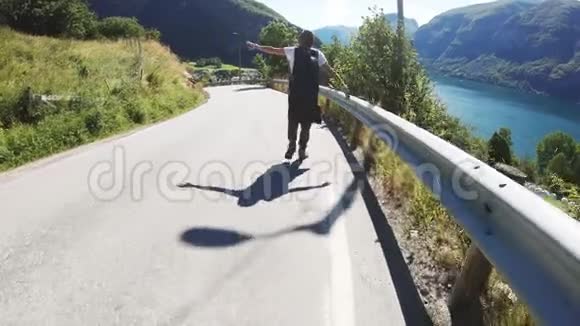 快乐的年轻女子背包客走在山路上可以看到风景视频的预览图