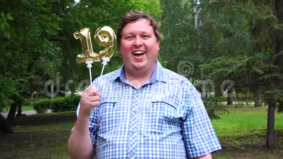 大个子拿着金色气球做19号户外19周年庆祝晚会视频的预览图